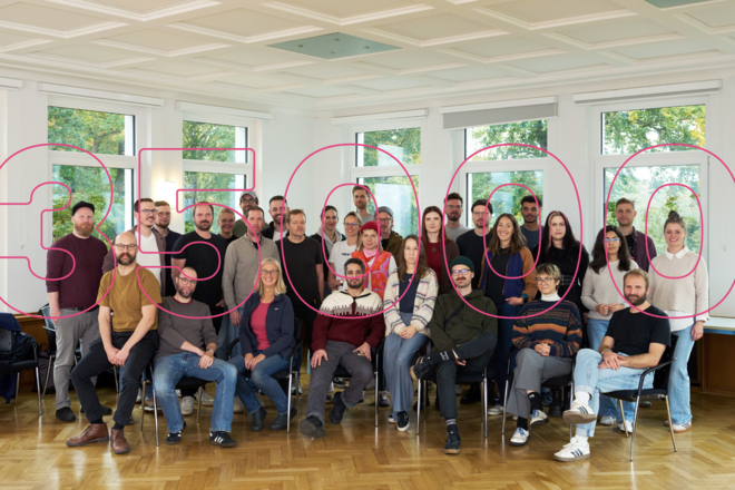 Gruppenbild der Mitarbeitenden von visuellverstehen mit rotem Stempel: 35 tausend.