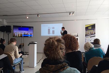 Viele Personen verfolgen bei der Social-Media-Week in Hamburg den Vortrag eines Dozenten in einem hellen Raum.