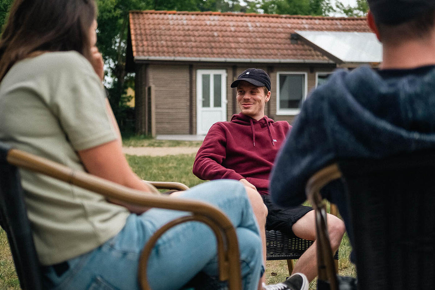 Mitarbeitende von visuellverstehen beim Sommerfest 2022 sitzen in gemütlicher Runde im Freien.