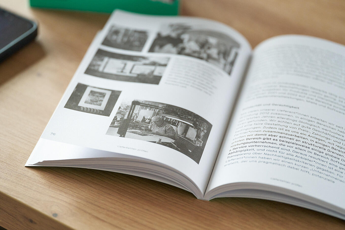Das visuellverstehen-Buch Gemeinwohl von A-Z aufgeschlagen auf einer bebilderten Seite auf einem Tisch.