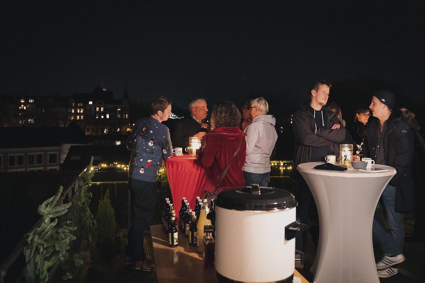 Mitarbeitende und Kund*innen von visuellverstehen beim Punschen auf der Dachterrasse des Unternehmens.