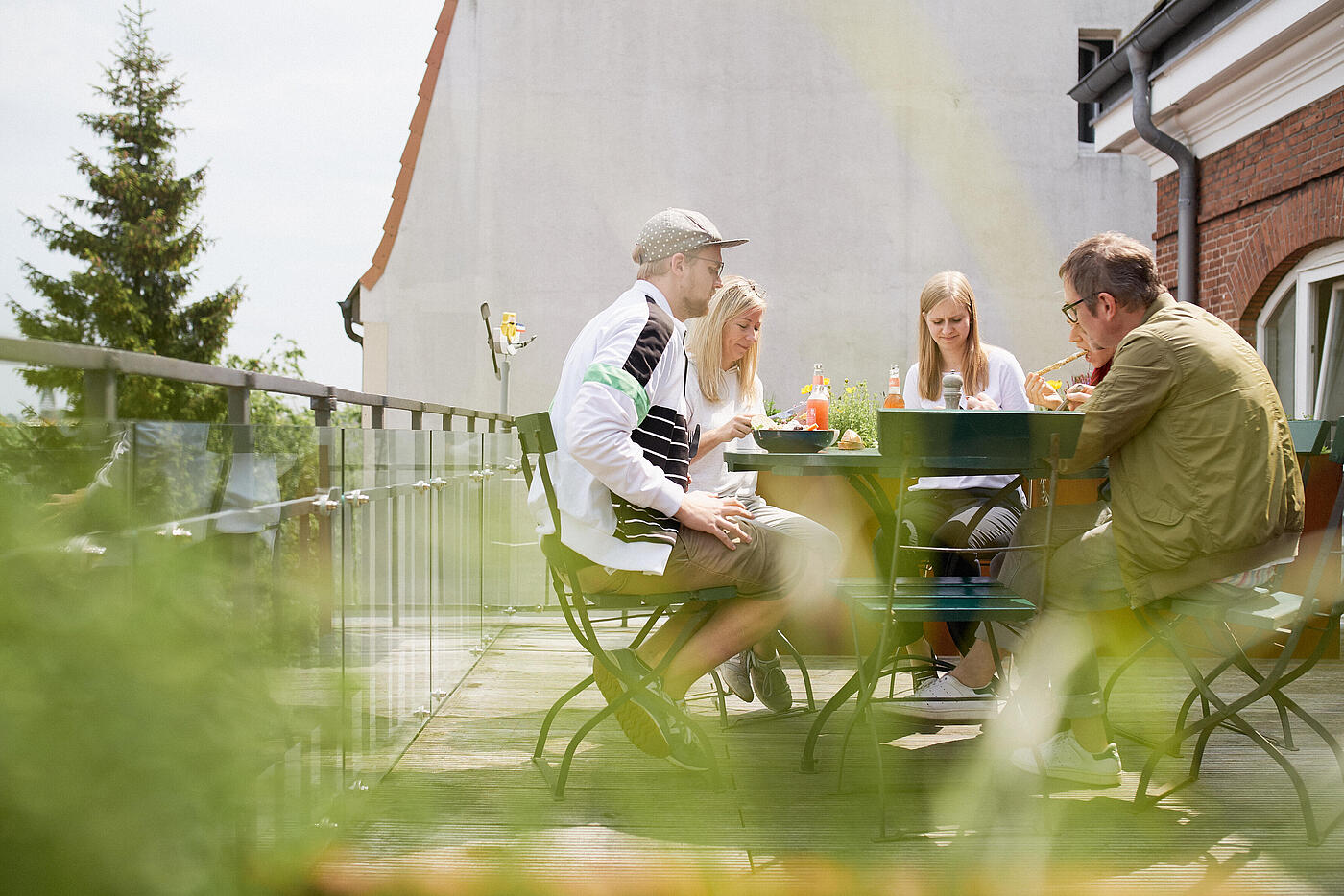 Mehrere Mitarbeiter von visuellverstehen essen zusammen auf dem Balkon.