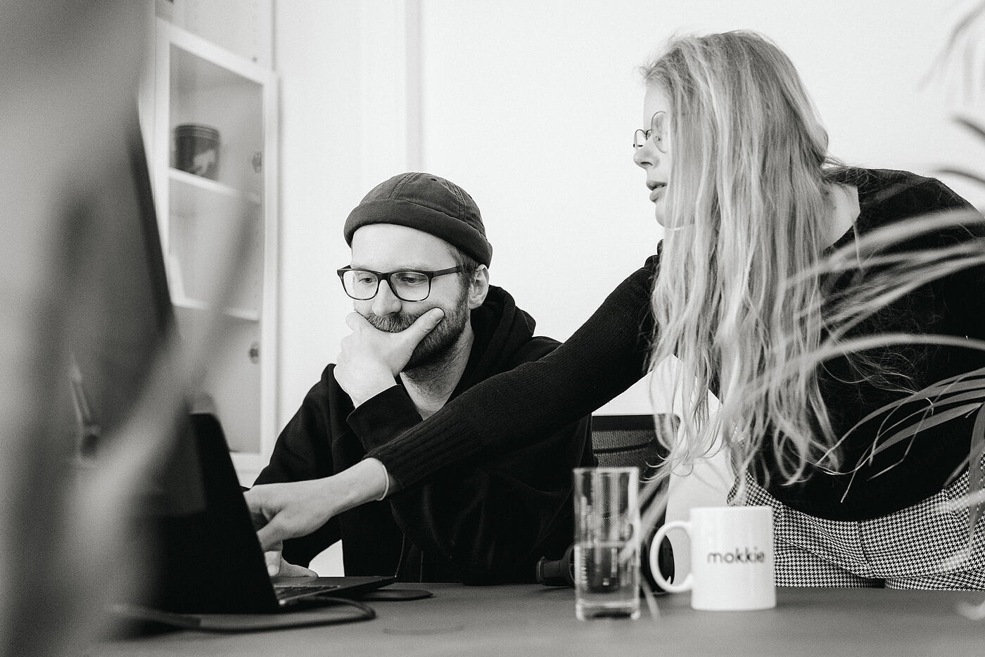 Zwei Mitarbeitende von visuellverstehen sitzen vor dem Computer und besprechen etwas.