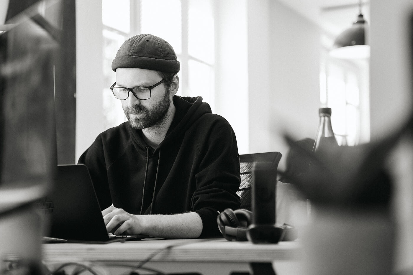 Ein Mitarbeiter von visuellverstehen sitzt am Computer. Das Bild ist in schwarzweiß gehalten.