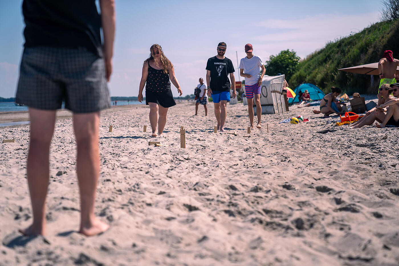 Mitarbeitende von visuellverstehen spielen am Strand Wikingerschach.
