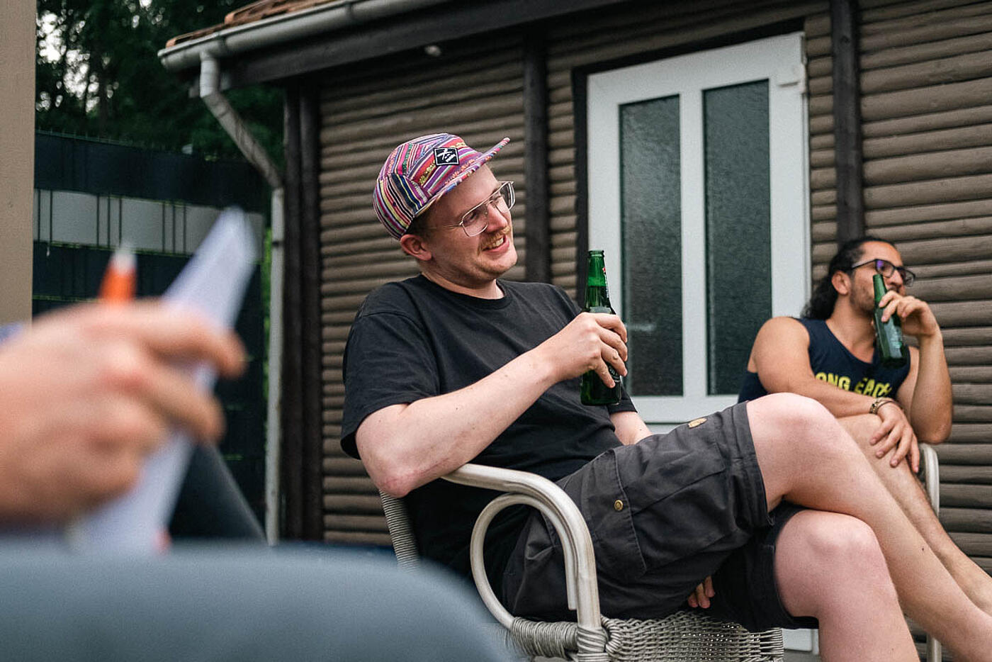 Mitarbeitende von visuellverstehen beim Sommerfest 2022 sitzen in gemütlicher Runde im Freien und nehmen erfrischende Getränke zu sich.