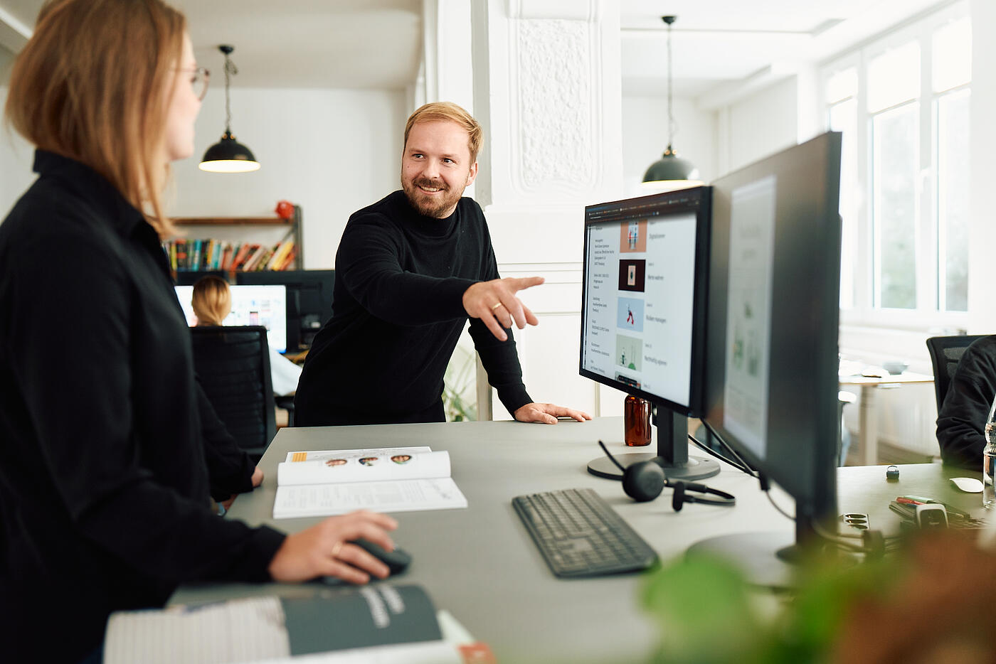Zwei Personen aus dem Team von visuellverstehen in den lichtdurchfluteten Räumen der Agentur.