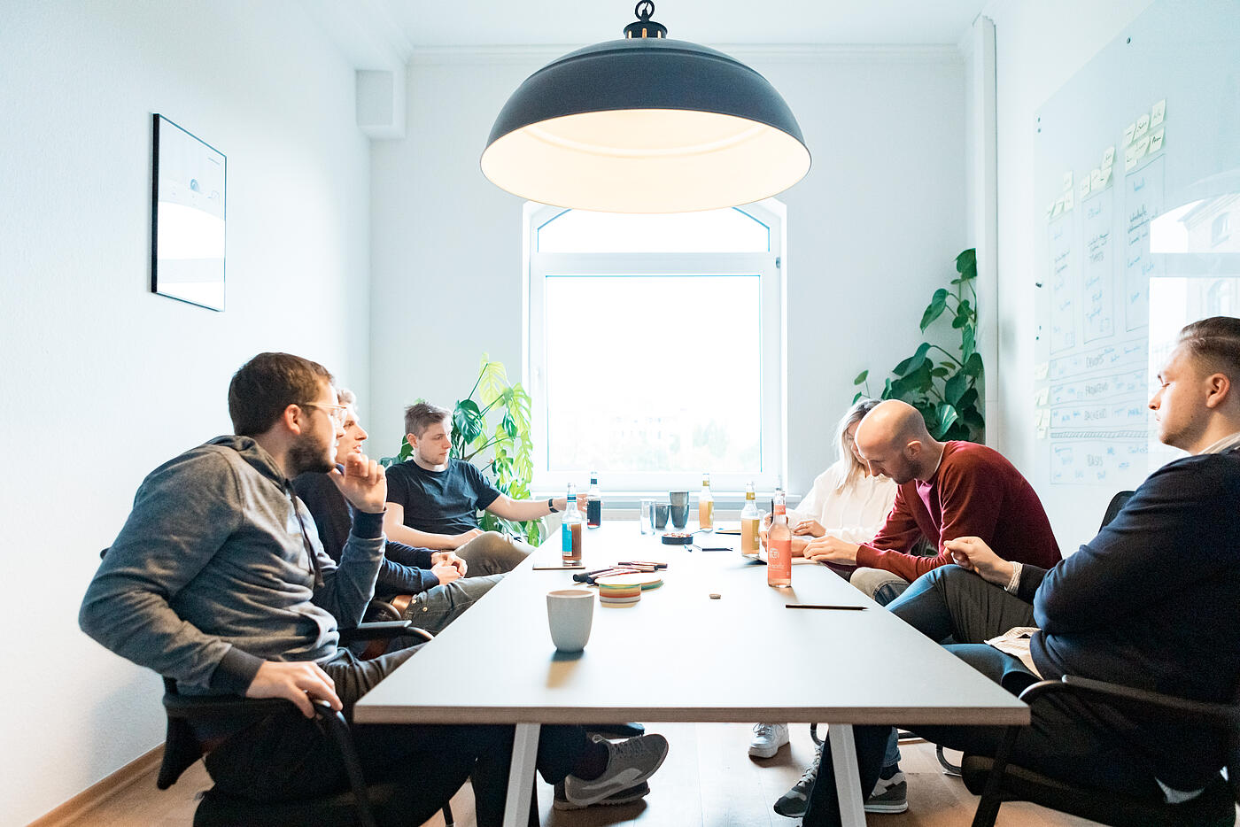 Mitarbeitende von visuellverstehen sitzen beim Open Friday in einem lichtdurchfluteten Besprechungsraum.