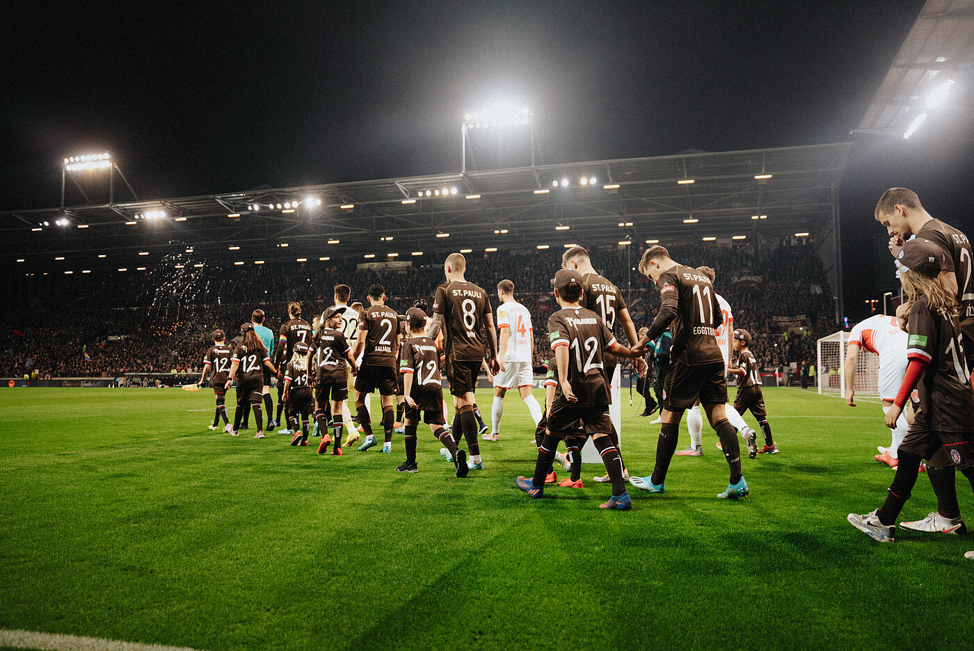 Fußballer im Millerntorstadion bei Nacht auf dem Rasen.