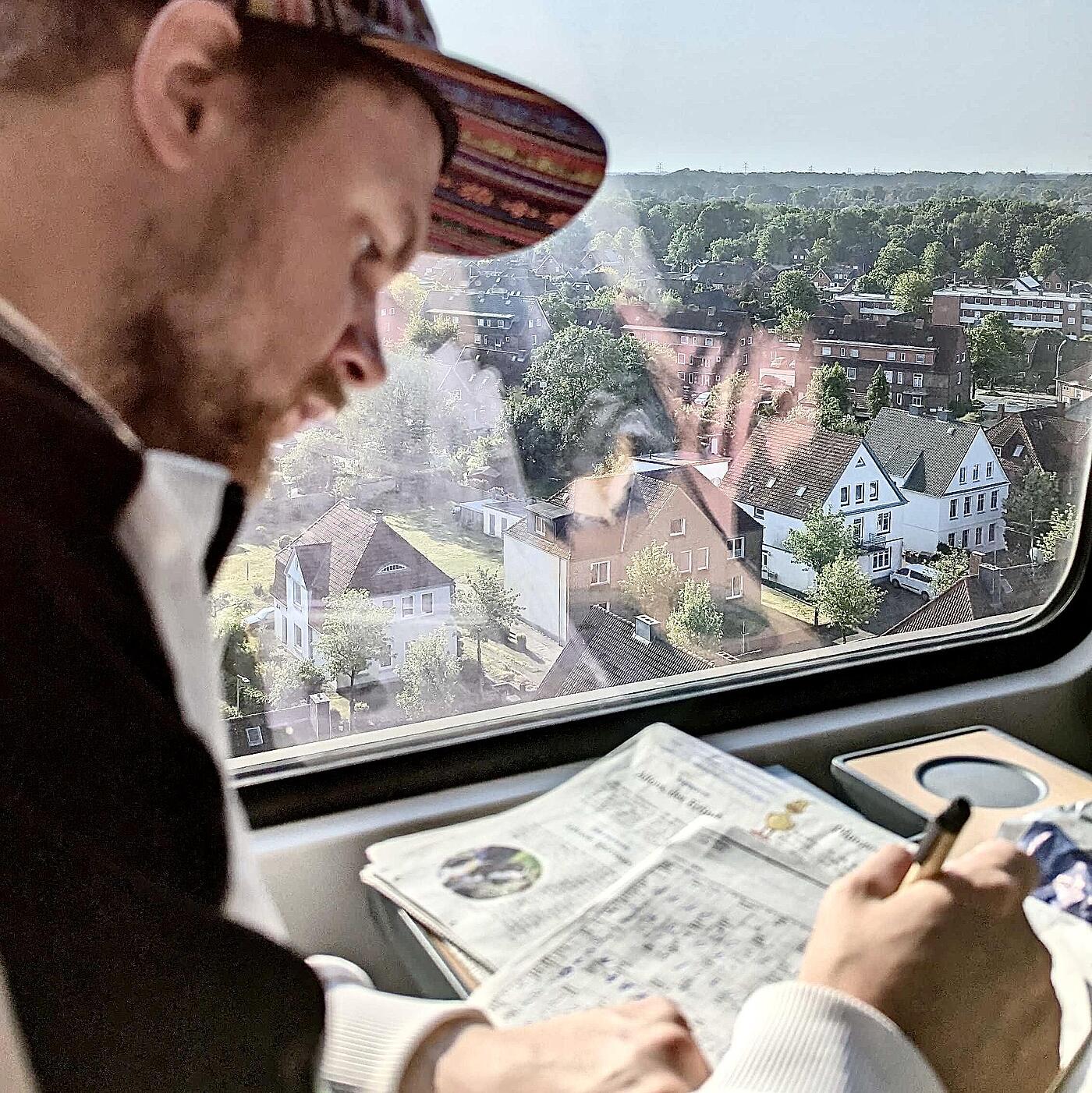 Ein Mitarbeiter von visuellverstehen löst auf der Zugfahrt Kreuzworträtsel.