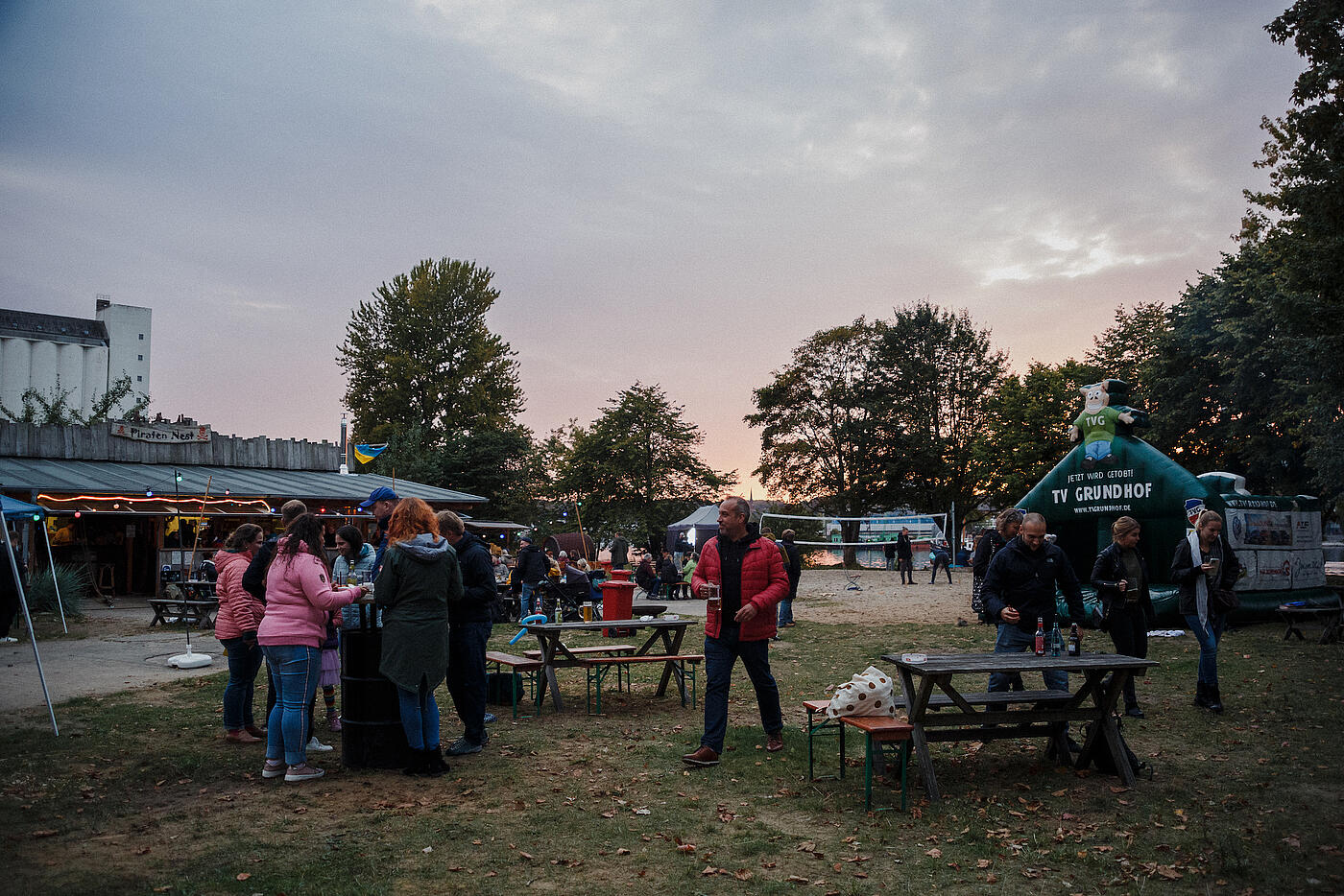 Das Flensburger Piratennest bei Sonnenuntergang, Menschen streifen umher.