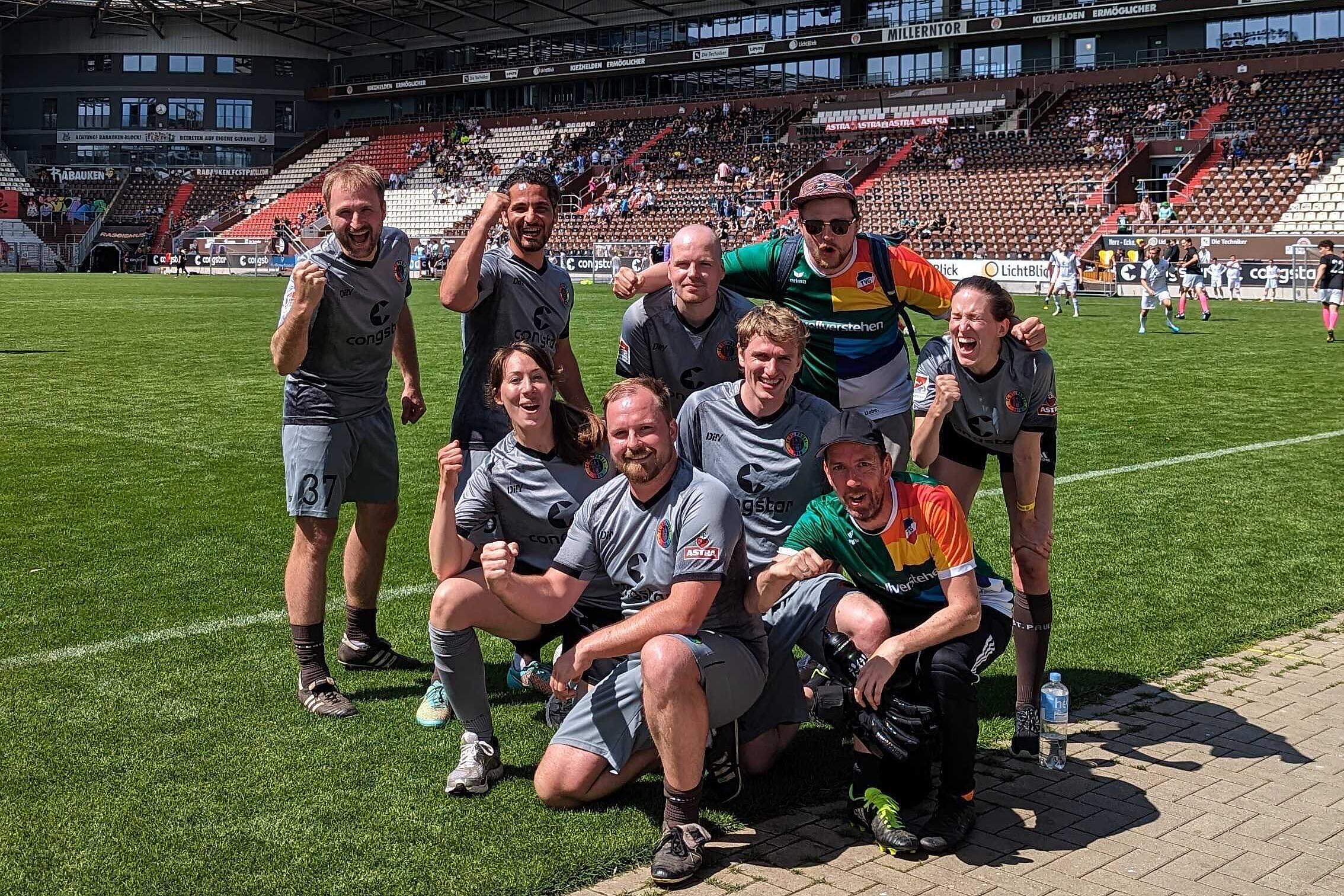 Mitarbeitende von visuellverstehen posieren in FC St. Pauli-Trikots im Stadion.