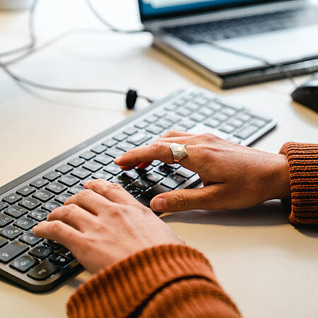 Zwei Wände tippen auf einer Tastatur.