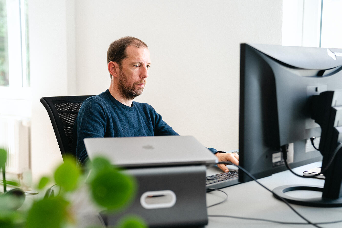 Ein Mitarbeiter von visuellverstehen sitzt am Computer.