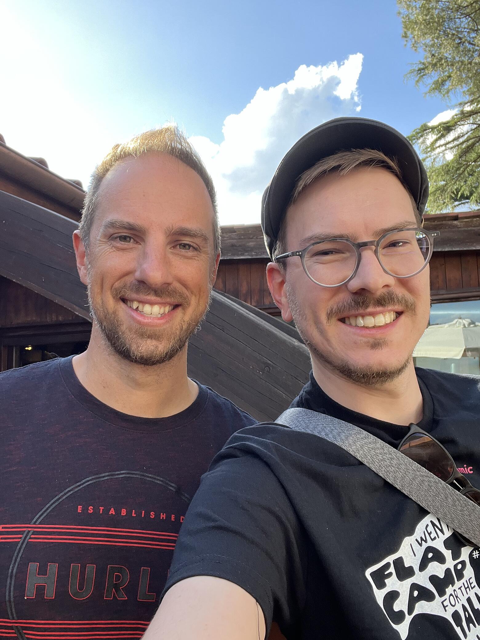 Zwei Männer lachen in die Kamera.
