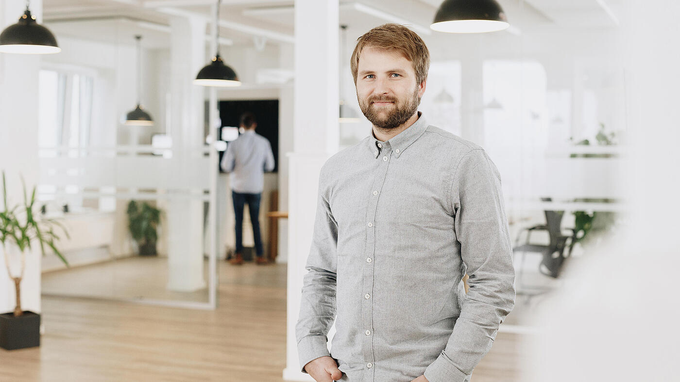 Porträt eines der beiden Geschäftsführer von visuellverstehen in den modernen Büroräumen der Digitalagentur.