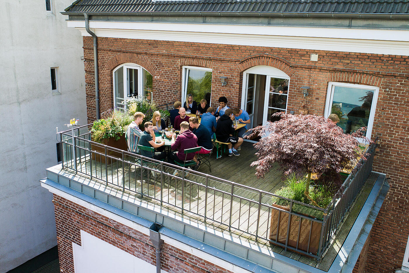 Mehrere Mitarbeiter von visuellverstehen essen zusammen auf dem Balkon.