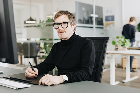 Porträt eines Mitarbeiters von visuellverstehen in den modernen Büroräumen der Digitalagentur.
