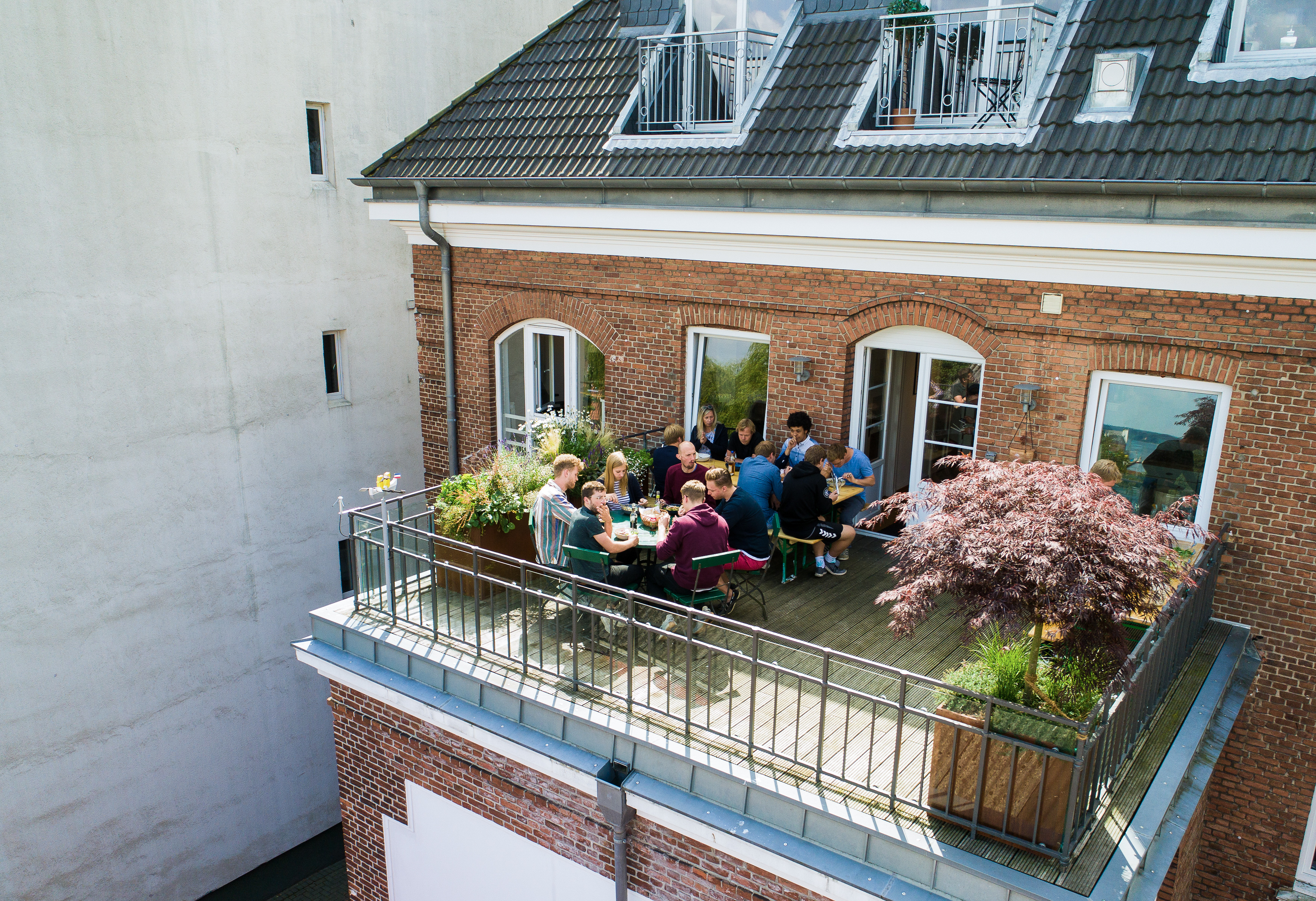 Mehrere Mitarbeiter von visuellverstehen essen zusammen auf dem Balkon.