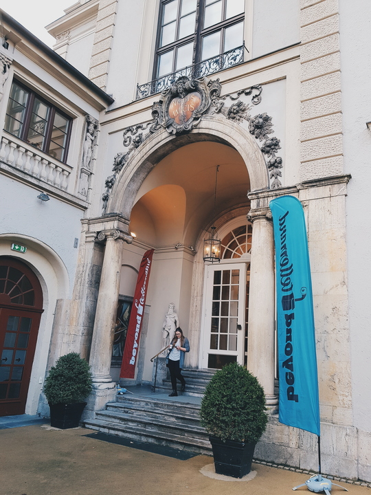 Eine junge Frau kommt aus dem herrschaftlichen Gebäude, in dem die Beyond Tellerrand-Veranstaltung stattfindet.
