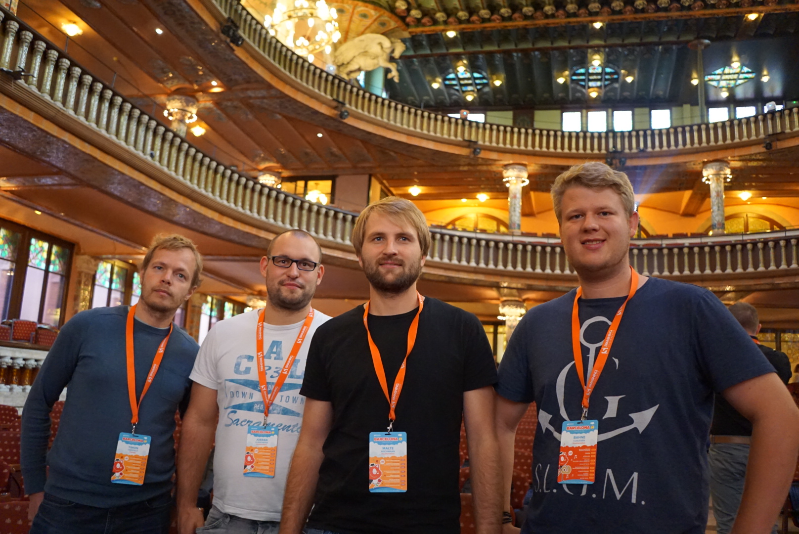 Vier Mitarbeiter von visuellverstehen stehen bei einer Konferenz in Barcelona in einem festlichen Saal.