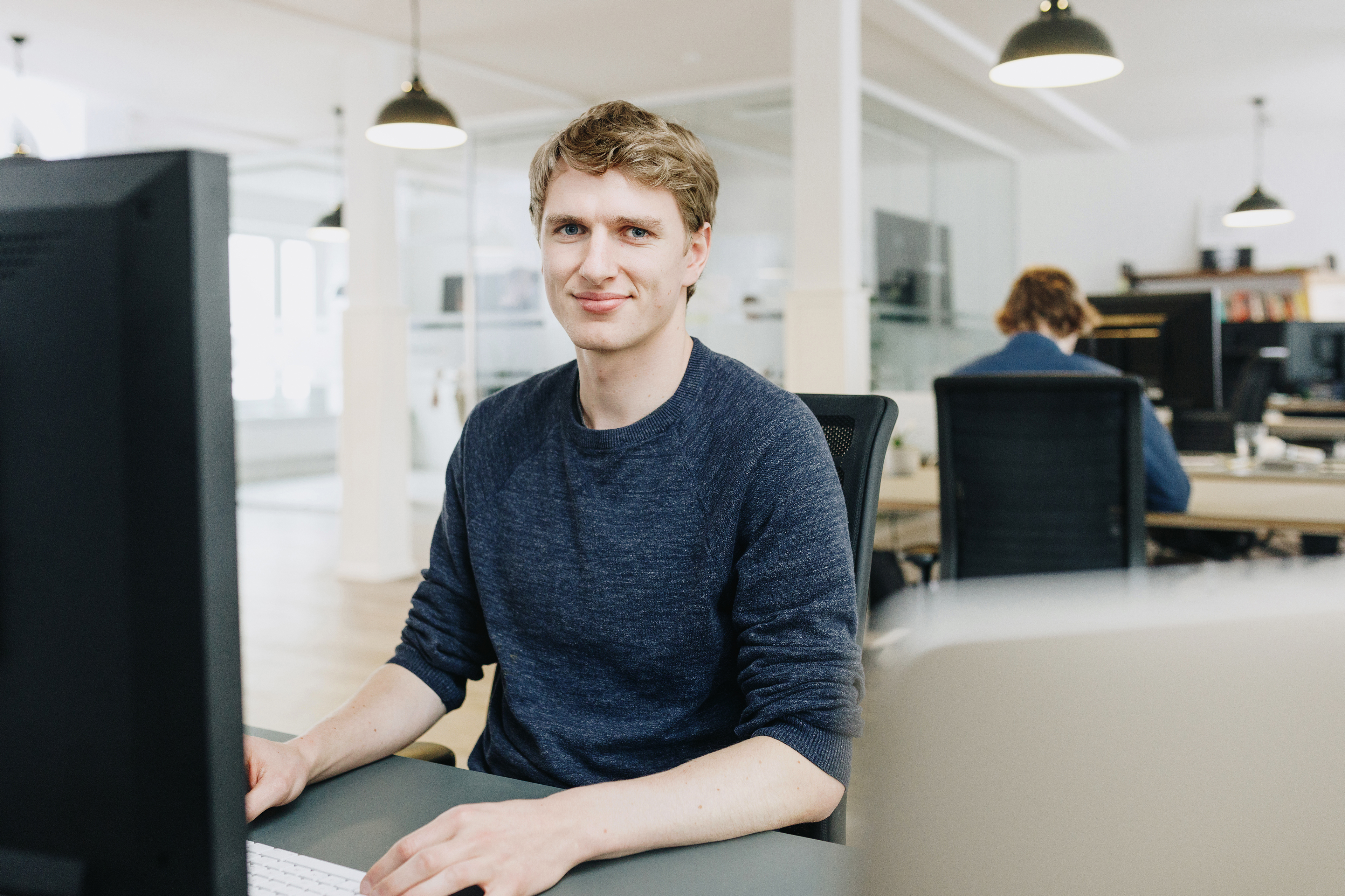 Porträt eines Mitarbeiters von visuellverstehen in den modernen Büroräumen der Digitalagentur.