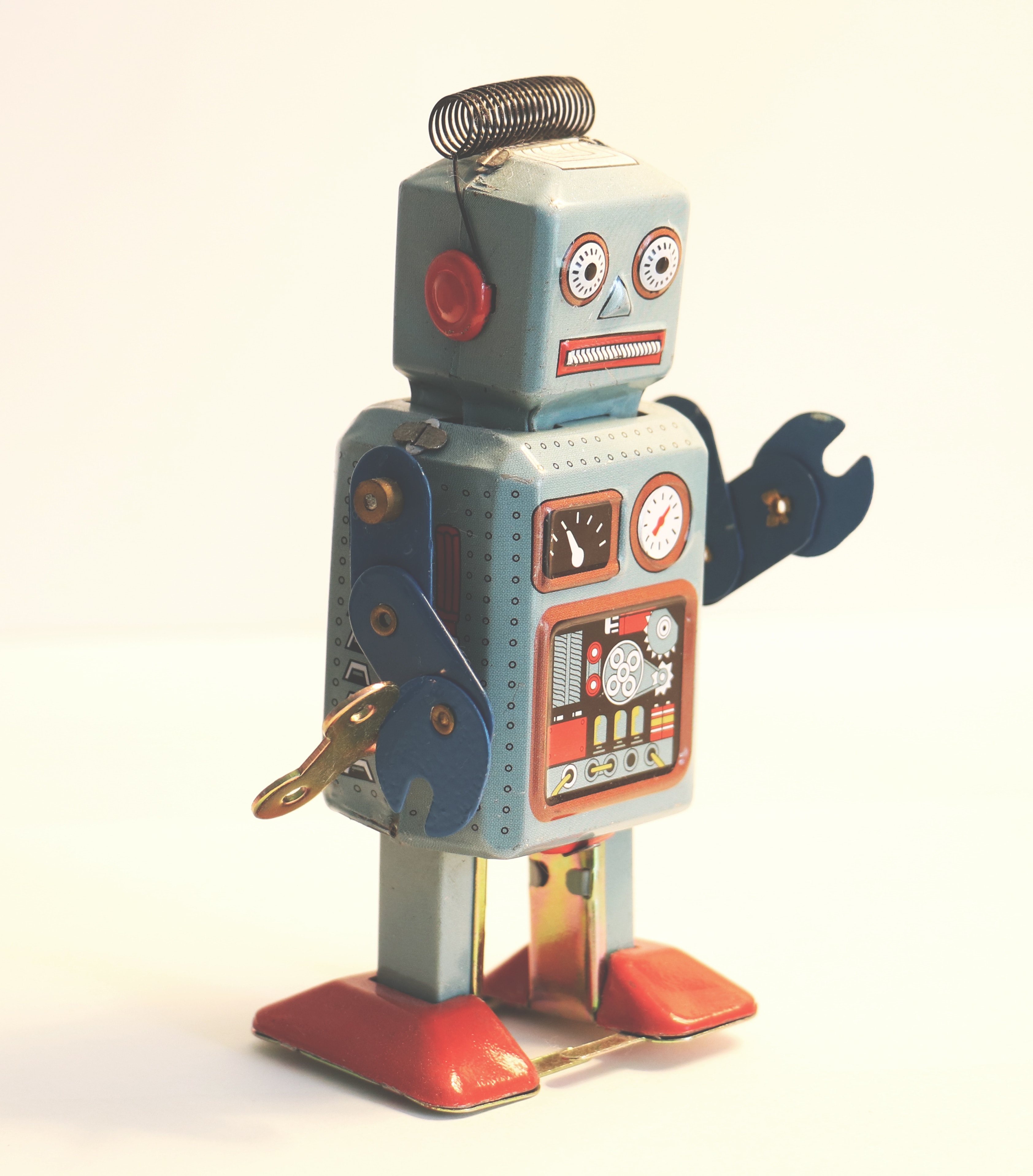 Ein grauer Roboter mit roten Füßen und einem Schraubenschlüssel als Hand.